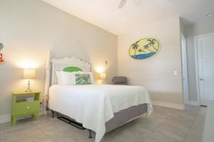 1 dormitorio con 1 cama grande con colcha blanca en Sunny Side Cottages en Dunedin