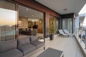 a living room with a couch on a balcony at CAG The Hub Bryanston in Johannesburg