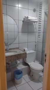 a bathroom with a toilet and a sink and a mirror at Gran Lençóis Flat in Barreirinhas