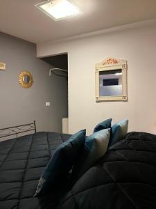 ein Schlafzimmer mit einem Bett mit blauen Kissen und einem Spiegel in der Unterkunft Da Esterina appartamento sulla riviera del Brenta in Mira