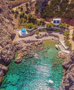 uma vista aérea de uma piscina de água numa montanha em Aesthisis Sensational Accommodation Archangelos em Archangelos