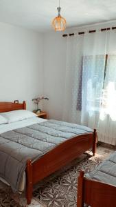 a bedroom with a large bed and a window at Bujtina Kometa in Theth