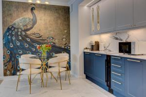 Una cocina con una mesa y un cuadro de pavo real en la pared. en Jacuzzi EnergyApart, en Szczecin