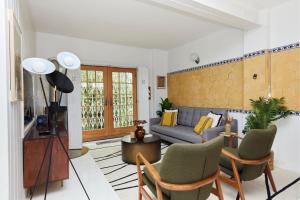uma sala de estar com um sofá azul e cadeiras em The Hampstead Wonder - Spacious 4BDR House with Balcony em Londres