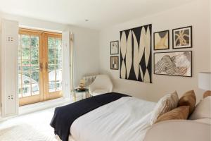 um quarto branco com uma cama e uma janela em The Hampstead Wonder - Spacious 4BDR House with Balcony em Londres