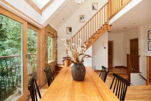 uma sala de jantar com uma mesa de madeira com um vaso em The Hampstead Wonder - Spacious 4BDR House with Balcony em Londres