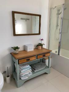 a bathroom with a table with a mirror and a tub at Pomona Noosa Hinterland Homestay in Pomona