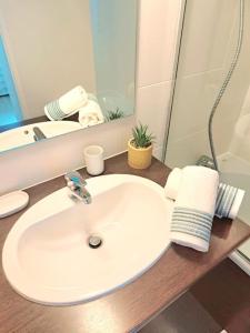 um balcão de casa de banho com um lavatório e um espelho em Le Valmy: appartement lumineux au pied du métro em Lyon