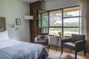 1 dormitorio con cama, escritorio y ventana en Mooirivier, en Dalfsen