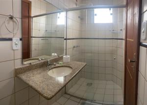 W łazience znajduje się umywalka i lustro. w obiekcie Pousada e Restaurante Palomar w mieście Ilhéus