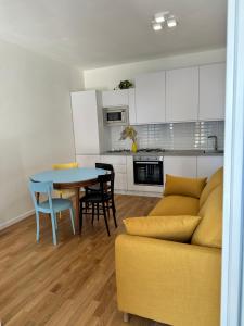 - une cuisine et une salle à manger avec une table et un canapé dans l'établissement A casa di Fede, à Porto Recanati