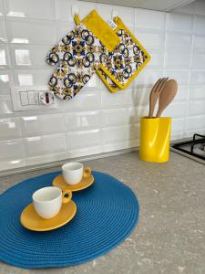 une cuisine avec deux tasses et des assiettes sur une table dans l'établissement A casa di Fede, à Porto Recanati