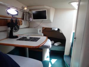 a small room with a desk and a television at yacht vedette Arlequin in Gruissan