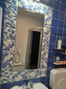 La salle de bains bleue et blanche est pourvue d'un miroir et de toilettes. dans l'établissement apartament Onestilor, à Oradea