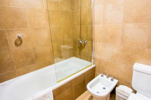 y baño con bañera, aseo y lavamanos. en Altos Ushuaia Hotel & Resto en Ushuaia