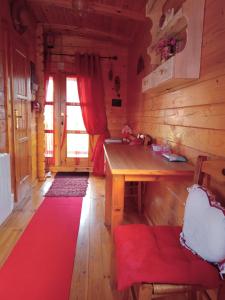 a room with a wooden table and a red rug at Roulotte la passe pierre in Pendé +20 photos
