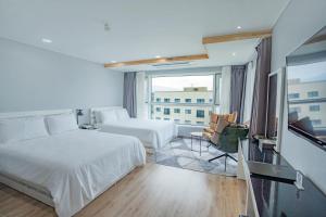 Postel nebo postele na pokoji v ubytování Hotel Sweet Castle Jeju Hamdeok