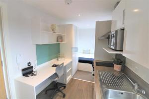 a small kitchen with a desk and a sink at Pass the Keys Centrally located studio Flat in Lincoln