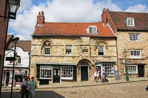 an old stone building with people standing in front of it at Pass the Keys Centrally located studio Flat in Lincoln