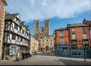 a city street with buildings with a cathedral in the background at Pass the Keys Centrally located studio Flat in Lincoln