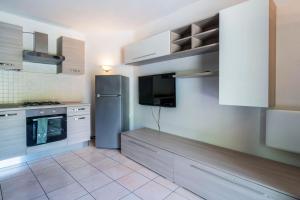 eine Küche mit einem Kühlschrank aus Edelstahl und einem TV in der Unterkunft Residence Covalou in Antey-Saint-André