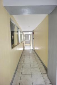 pusty korytarz z podłogą wyłożoną kafelkami w budynku w obiekcie Rivoli Hotel w mieście San Pablo