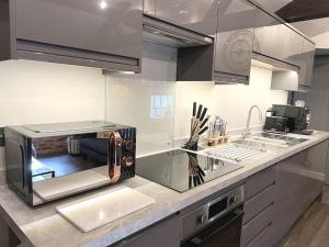 a kitchen with stainless steel cabinets and a counter top at Luxury 2 Bed Penthouse - 4K Projector - Snug Room - En Suite in Birmingham