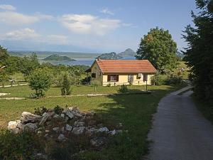 a small house with a road next to a field at Soba in Čukovići