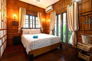 een slaapkamer met een bed en een groot raam bij Villa Ayutthaya at Kantiang Bay in Koh Lanta