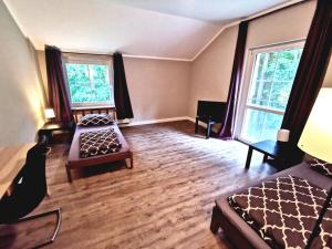 a bedroom with a bed and a couch and two windows at Monteurzimmer am Bahnhof Biesenthal - 2 große Apartments in Biesenthal