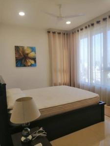 a bedroom with a bed and a lamp and a window at Luxury Sea view fully furnished apartment in Colombo