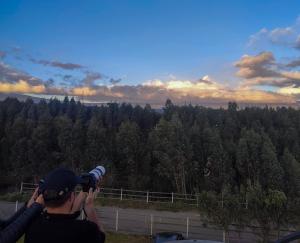 osoba robiąca zdjęcie lasu w obiekcie Cuscungo Cotopaxi Hostel & Lodge w mieście Chasqui