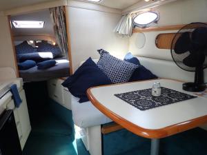 Habitación pequeña con mesa y cama en yacht vedette Arlequin, en Gruissan