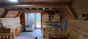 a kitchen in a log cabin with a window at Eko katun Vranjak, koliba 28 in Vranjak