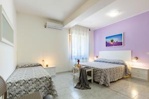 1 dormitorio con 2 camas y paredes moradas en Il Magnolia, en Francavilla al Mare