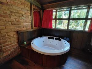 a bath tub in a room with a brick wall at Kanawha Hotel in Nova Friburgo