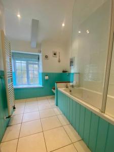 a bathroom with a tub and a toilet and a window at Brook Cottage is a traditional fisherman's cottage in Port Isaac
