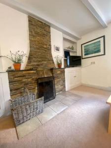 a living room with a stone fireplace in a house at Brook Cottage is a traditional fisherman's cottage in Port Isaac