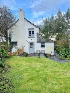 a white house with a picnic table in front of it at Brook Cottage is a traditional fisherman's cottage in Port Isaac