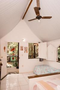 Habitación con cama y ventilador de techo. en Pousada Cajibá Imbassaí en Imbassai