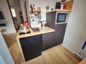 a small kitchen with a sink and a microwave at La MerVeille / MRODBnB in Cancale