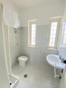 een witte badkamer met een toilet en een wastafel bij Be Home in Pontecagnano