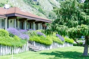 a house with a fence and purple flowering bushes at Luxuriöse Villa Romantica in Gampel