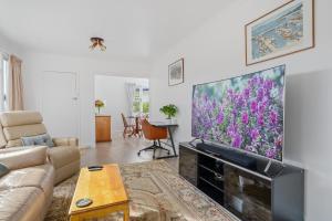 Una sala de estar con un televisor de pantalla plana grande. en Sunny Beach Holiday Home 80, en Kingston Beach