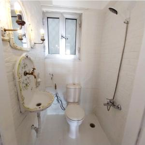 La salle de bains est pourvue de toilettes, d'un lavabo et d'une fenêtre. dans l'établissement Omar Apartment, au Caire