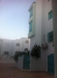 a white building with plants in front of it at Tunis Comfort Family Home in Burj at Turkī