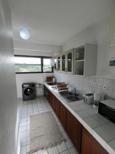 uma grande cozinha com um lavatório e uma janela em Appartement F3 avec acces plage à Montjoly em Montjoly