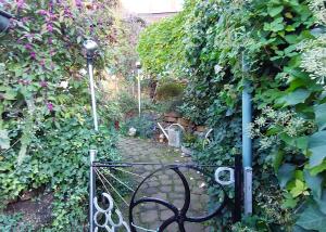 a metal gate in a garden with ivy at Beim Schlafwandler in Karlsbad