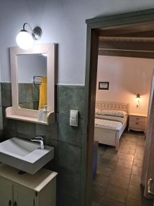 een badkamer met een wastafel, een spiegel en een bed bij Penzion U vinaře in Velké Bílovice