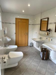 a bathroom with two sinks and a toilet and two sinks at Ferienwohnung Göttert – Haus Erika in Beckingen +20 photos